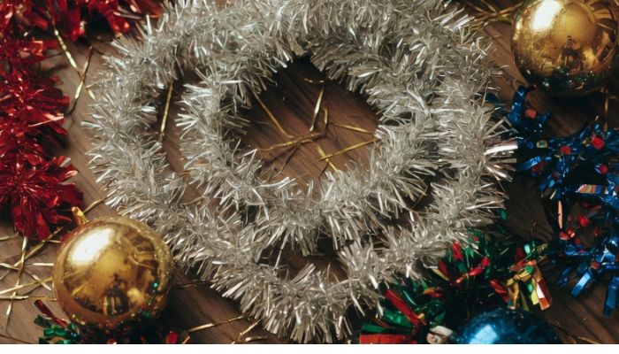 1980s Christmas decoration materials including silver tinsel lametta multicoloured glass baubles on period surface - grok imagine