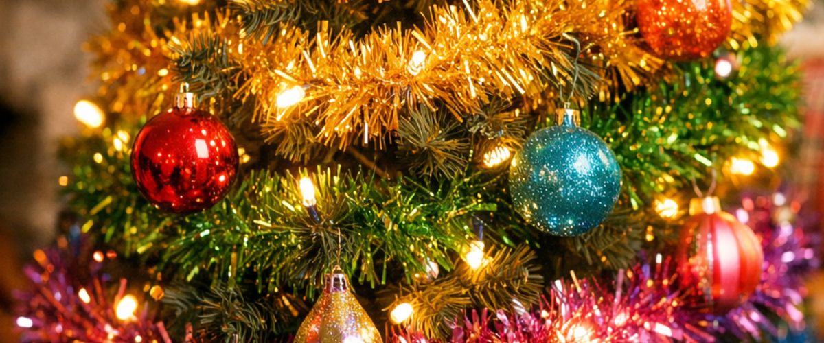 Close-up of a colourful Christmas tree decorated with layers of rainbow tinsel and warm fairy lights 