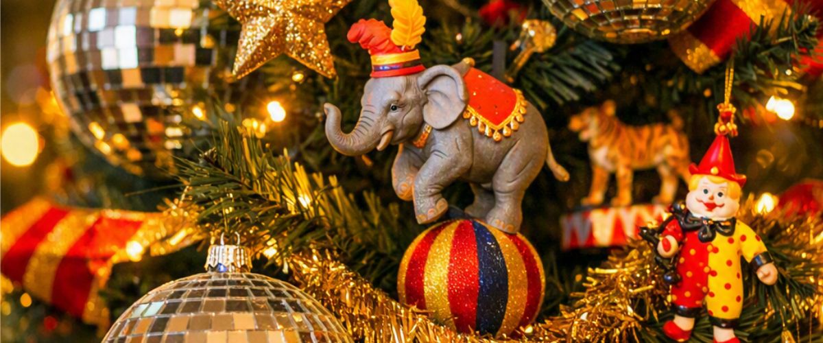 Circus and disco themed Christmas tree decorated with mirror balls, elephant ornaments, clown figures and gold striped ribbon